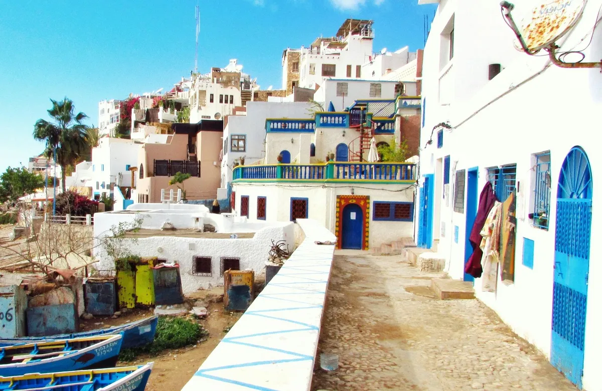 Ruelle blanchie à la chaux et barques de pêche sur la côte marocaine, où François Secula se déplace pour estimer